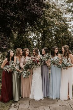 a group of women standing next to each other holding bouquets