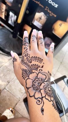 a woman's hand with henna tattoos on it