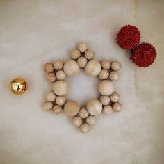 two pieces of wood sitting on top of a table next to a red ball and gold object