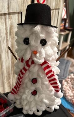 a snowman made out of yarn with a hat and scarf