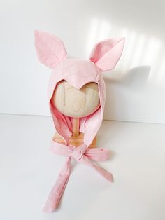 a pink bunny hat on top of a wooden stand