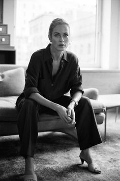 a black and white photo of a woman sitting on a couch in a living room