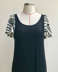 a dress on a mannequin with white and black stripes around the neckline