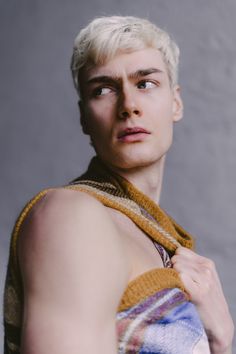 a young man with white hair and no shirt is wearing a towel around his neck