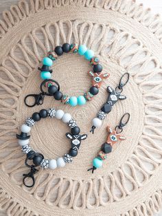 three different bracelets on top of a doily next to scissors and other items