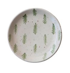 a white bowl with green trees on it