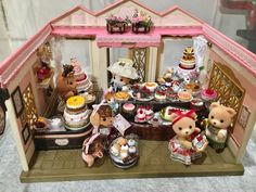 a doll house with teddy bears and cakes in it's display case on the floor