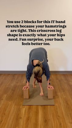 a woman standing on two blocks in the middle of a yoga pose with her head down