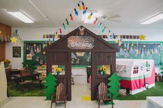 an indoor classroom decorated for christmas with decorations on the ceiling and green grass around it