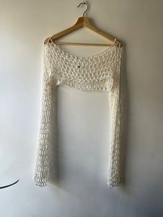 a crocheted top hanging on a wall