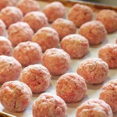 raw meatballs on a baking sheet ready to be cooked