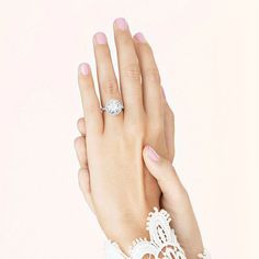 a woman's hand with a ring on top of her finger and lace around it