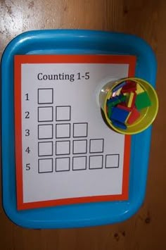 a close up of a child's activity board on a wooden surface with numbers and shapes