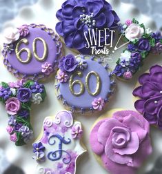 purple and white decorated cookies sitting on top of a cake plate with the number 60