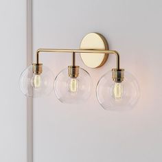 three clear globe lights are mounted on the wall