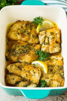 chicken with lemon and parsley in a blue casserole dish