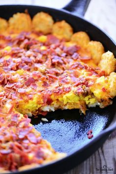 an omelet with bacon is in a skillet on the table, ready to be eaten