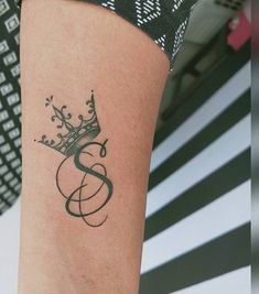 a woman's arm with a tattoo on it that has a crown on it