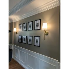 a wall with four framed pictures on it and a piano in the corner next to it