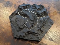 a piece of stone with a map on it sitting on top of a wooden table