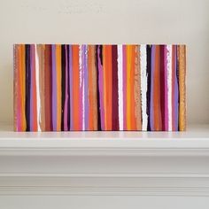 a colorful painting on top of a white mantle