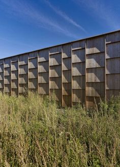 a wooden structure in the middle of some tall grass