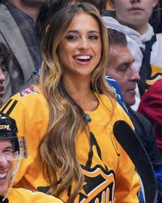 a woman in a hockey uniform standing next to a man