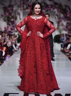 a woman in a red gown on the runway