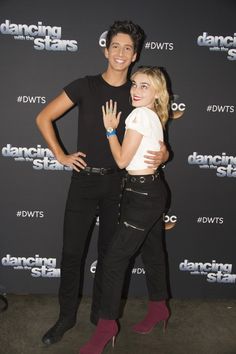 two people standing next to each other in front of a black background with the words dancing with the stars on it