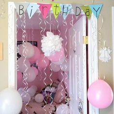 a birthday party with balloons and streamers on the door way to a room that is decorated in pastel colors