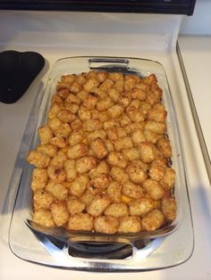 a casserole dish with tater tots sitting on top of a stove