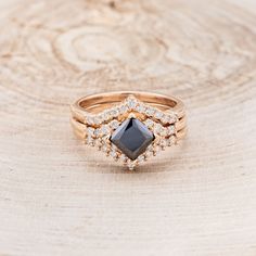 a close up of a ring on top of a wooden surface with diamonds around it