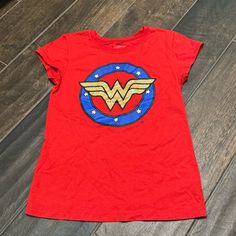 Gently Loved In Excellent Condition. It’s Possible This Was Never Worn. Brand: Wonder Woman Girls Graphic Tee Red, Blue, & Gold Wonder Woman Symbol Gold Part Is Glittery Cap Sleeves 50% Cotton/50% Polyester Size L (10/12) At-3 Red Superhero T-shirt With Character Print, Red Cartoon Print Graphic Tee, Superhero Cartoon Print Cotton T-shirt, Red Short Sleeve Fandom Top, Red Short Sleeve Fandom Tops, Superhero Cotton Tops With Cartoon Print, Superhero Cartoon Print Cotton Tops, Red Cotton Pop Culture Tops, Pop Culture Red Top With Character Print