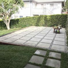 an empty backyard with grass and stepping stones