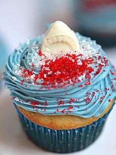 a cupcake with blue frosting and red sprinkles