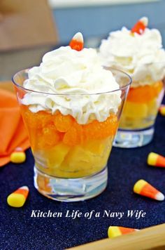 an orange and white dessert in a glass bowl with whipped cream on top, sitting on a table