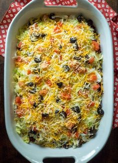 a casserole dish with cheese, olives and other toppings in it