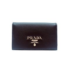 This Pradavitello grain blackcard holder is absolutely adorable and is the perfect size for your personal information. Thepebbled soft leather is sure be the classic accessory you need. The gold Prada Paris logo looks amazing with thesimple black leather. Includes authenticity cards and Prada box. Model: 1MC122 Measurements: 4.5 x 1 x 2.5 inches Black vitello grainleather Card holder/ wallet Gold Prada logo Includes authenticity cards and Prada box Size: one size.  Gender: female.  Age Group: ad Black Rectangular Card Holder With Logo Plaque, Everyday Wallets With Logo Plaque, Black Wallets With Logo Plaque For Everyday Use, Leather Wallets With Logo Plaque For Everyday, Leather Wallets With Logo Plaque, Luxury Compact Card Holder For Daily Use, Black Leather Card Holder With Logo Plaque, Classic Black Card Holder With Logo Plaque, Elegant Black Card Holder With Logo Plaque