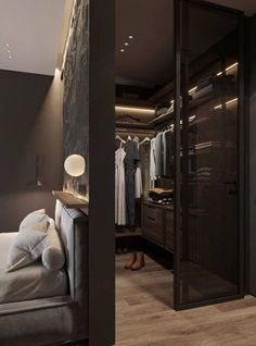 an open closet with clothes hanging on hangers and a bed in the foreground