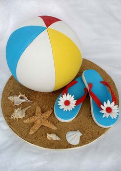 a beach ball, flip flops and starfish on top of a sand tray