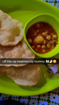 a green plate topped with pita bread next to a bowl of soup