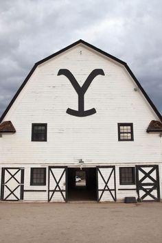 a large white barn with a black and white letter y on it