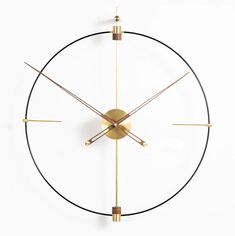 a clock that is on the side of a wall with gold trimmings and hands