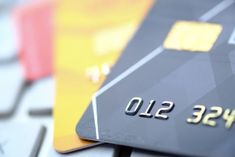 a credit card sitting on top of a computer keyboard next to another one that is yellow and black