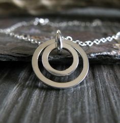 "Just a little something to catch the light. The Details ∞ Artisan handmade ∞ Sterling silver ∞ Largest ring measures about 13mm ∞ Sterling silver 1.5mm dainty cable chain with spring ring clasp ∞ Please choose the length of chain you prefer ~ up to 20\" ∞ Made to order Θ Allow up to 14 business days before shipment Θ ∞ Gift box included ∞ Made in the USA You can find more of our simply metal necklaces here.... https://www.etsy.com/shop/PoseidonsBooty?section_id=6081264 VISIT OUR SHOP: http://ww Delicate Circular Sterling Silver Jewelry, Sterling Silver Circle Jewelry With Simple Design, Delicate Circle Sterling Silver Jewelry, Sterling Silver Jewelry With Simple Design, Simple Sterling Silver Full Circle Jewelry, Simple Full Circle Sterling Silver Jewelry, Dainty Full Circle Sterling Silver Jewelry, Dainty Pendant Necklace, Dainty Pendant