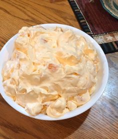 a white bowl filled with food on top of a wooden table