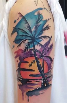 a woman's arm with a palm tree and watercolor paint splashes on it