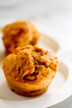 two muffins sitting on top of a white plate