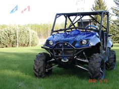 a blue four - wheeler is parked in the grass