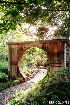 a wooden arch in the middle of a forest